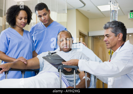 Afrikanischer Mann in Krankenhaus Bahre Zwischenablage betrachten Stockfoto