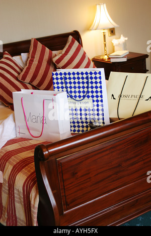 Einkaufstüten auf Hotelbett. Stockfoto