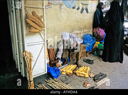 Afrika Kenia MOMBASA barfuß muslimischen Anbieter ordnet seine Holzlöffel und hält sich für den Verkauf auf der anderen Straßenseite von Mombasa mit Mus Stockfoto
