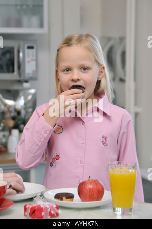 junge 7 Jahre alte Blondine Essen einen donut Stockfoto