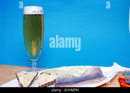 Fisch auf Teller mit Bier blauer Hintergrund Stockfoto