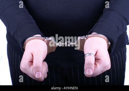 Frau in Handschellen (close-up Schwerpunkt Hände) / Junge Frau in Handschellen Stockfoto