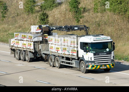 LKW & Anhänger beladen mit Netz überdachten Bausteine LKW mit sich selbst ausgestattet entlasten Kran Stockfoto