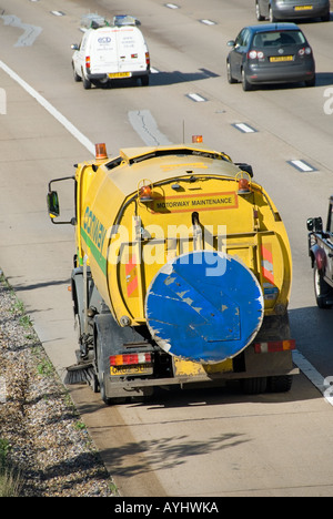 M25 Autobahn mechanische Kehrmaschine arbeitet auf dem Standstreifen neben verschüttete Französisch Kanalisation Kies Stockfoto