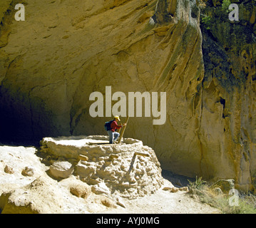 Ein Wanderer steigt in einem alten Anasazi Indian Kiva oder religiöse Struktur in zeremoniellen Höhle im Bandelier in den Jemez Bergen Stockfoto