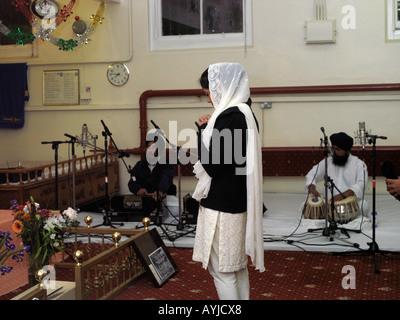 Khalsa Zentrum Tooting London England Mädchen beten im Gebetssaal Raggis spielen Harmonium und Tabla Drums Stockfoto