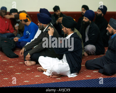 Khalsa Zentrum Tooting London England Gemeinde in Gurdwara mit Männern tragen verschiedene Arten am Turban Mann dabei fotografieren Stockfoto