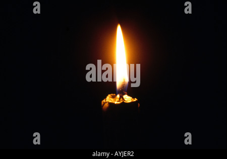 Leuchtende Kerze In die dunklen Messing Leuchter Stockfoto