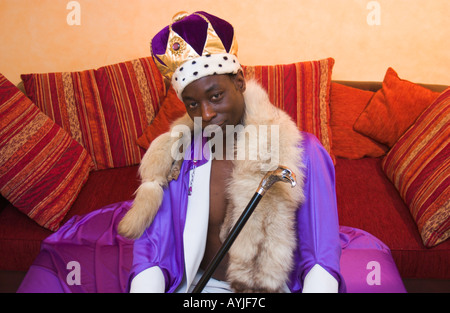 dunkel-enthäutete Mann posiert als afrikanische Konig Stockfoto