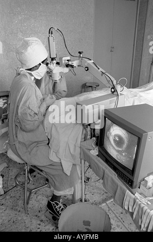 B/W eines Augenchirurgen, der eine Kataraktoperation mit Vergrößerung auf einem Monitor im Asmara-Krankenhaus durchführt. Asmara, Eritrea Stockfoto