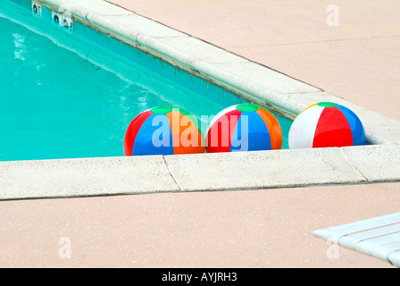 Drei bunte Wasserbälle in der Ecke des Pools veranschaulicht das Konzept der wie Menschen zusammen angezogen Stockfoto