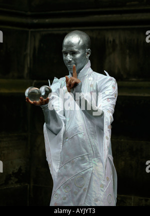 Männliche Street Performer gekleidet in Silber unterhaltsam mit Kristallkugeln Edinburgh Fringe Festival, Schottland Stockfoto