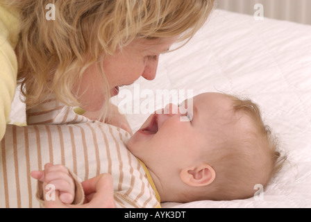 Mutter und Kind auf einem Bett zusammen spielen Stockfoto