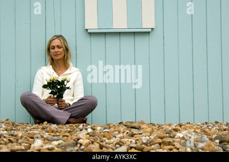 Reife Frau mit einem Blumenstrauß zu sitzen Stockfoto