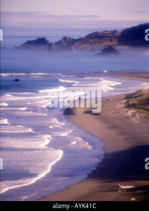 Am frühen Morgennebel und Nebel mit brechenden Wellen an der Küste von der Küste von Oregon in der Nähe von Cape Blanco Oregon USA Stockfoto