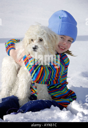 Kind und ihr Hund im Schnee Stockfoto
