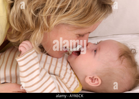 Mutter und Kind auf einem Bett zusammen spielen Stockfoto