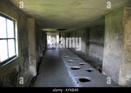 Latrinen in einer Latrine Block auf das ehemalige Konzentrationslager in Auschwitz-Birkenau. Stockfoto