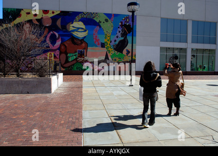 Touristen fotografieren ein Wandbild an der West 125th Street in Harlem in New York City Stockfoto