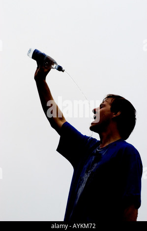 Läufer, die Abkühlung durch strömenden Wasser über ihren Köpfen Stockfoto