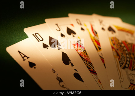 HAND VON SPIELKARTEN, DIE ROYAL FLUSH AUF GRÜNEM TUCH-SPIELTISCH Stockfoto