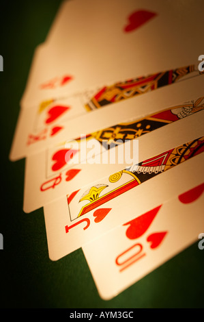 HAND VON SPIELKARTEN, DIE ROYAL FLUSH AUF GRÜNEM TUCH-SPIELTISCH Stockfoto