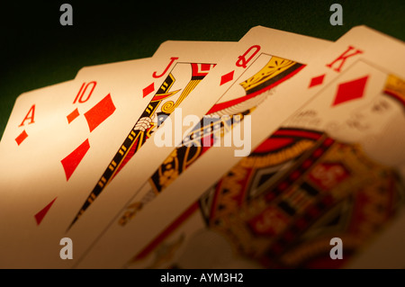 HAND VON SPIELKARTEN, DIE ROYAL FLUSH AUF GRÜNEM TUCH-SPIELTISCH Stockfoto