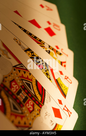 HAND VON SPIELKARTEN, DIE ROYAL FLUSH AUF GRÜNEM TUCH-SPIELTISCH Stockfoto