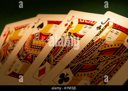 HAND DES SPIELENS KARTEN ANZEIGEN VON VIER BUBEN AUF GRÜNEM TUCH-SPIELTISCH Stockfoto