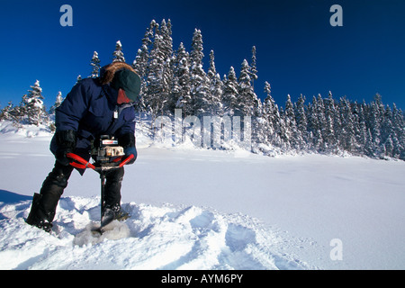 Mann ins Loch Eis an einem kalten verschneiten Wintertag Stockfoto