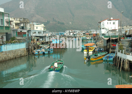 Ein Fischerboot tritt am Hafen von Tai O, Lantau Island, Hong Kong. Das Dorf Pfahlbauten entnehmen bitte den Backgroud. Stockfoto