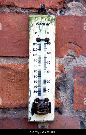 Alten Span Thermometer zeigt 50 Grad Fahrenheit gegen eine notleidende roten Backsteinmauer Stockfoto