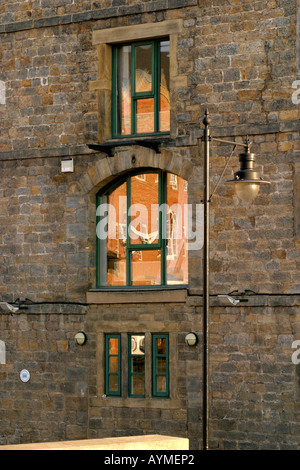 Reflexionen im Fenster des Büros im alten Getreidespeicher Wharf Kanal bauen jetzt renovierten Leeds England Stockfoto