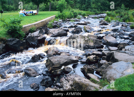 Schnellen Bach, der zwischen Steinen mit bräunlichen Kupfer farbigen Jets, Nordamerika, Michigan, obere Halbinsel, USA Stockfoto