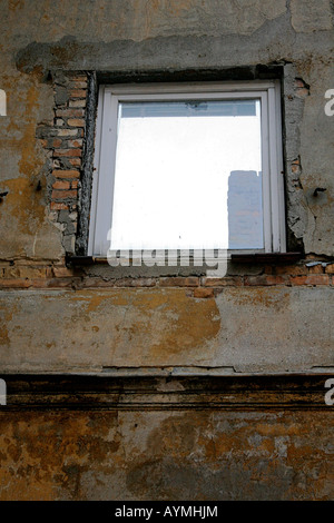 Spiegelbild im Fenster "ist Teil eines alten verwitterten Gebäudes". Stockfoto