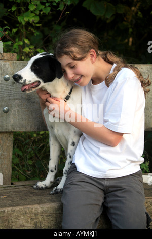 Tara Dalmation Hund weiß schwarze Flecken Auge Mädchen lieben Monty Besitzer Sitzbank kuscheln glückliches Lächeln Stockfoto