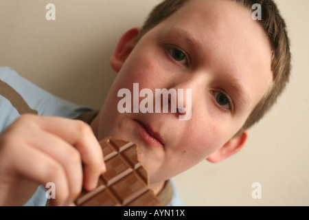 11 Jahre alter Junge, Schokolade zu essen Stockfoto