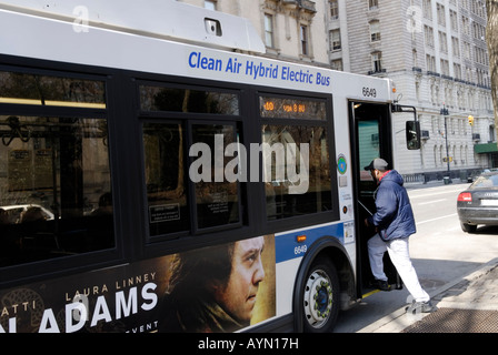 Person einsteigen in ein Gas Elektro-Hybrid-Bus auf der Strecke auf der Upper West Side von Manhattan Stockfoto