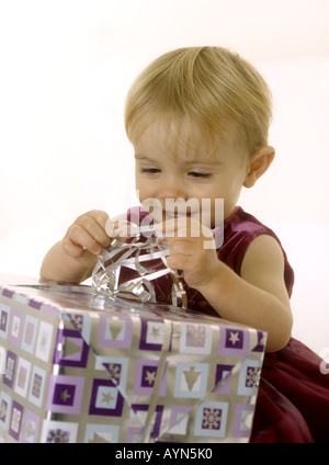 Babymädchen öffnen ein Weihnachtsgeschenk Stockfoto