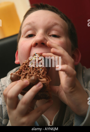 11 Jahre alter Junge, Kuchen essen Stockfoto