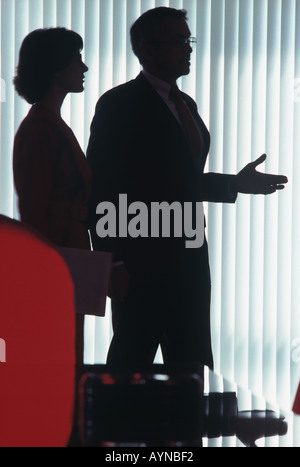 Silhouette einer Business-frau und Geschäftsmann Gestik und gleichzeitig einen Punkt in der Sitzung im Amt Stockfoto