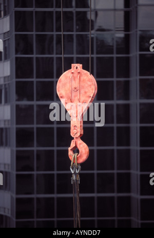 Massive orange Haken und Riemenscheibe, die an einer Bau Kran einen schweren Gegenstand in Midtown Manhattan Neubau Projekt angehängt Stockfoto