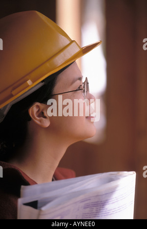 Portrait einer weiblichen Asiatischen amerikanischer Ingenieur trägt einen Schutzhelm auf dem Job in einer Baustelle Stockfoto