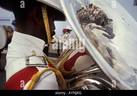 Intelligenter Bandsman des Royal Bermuda Regiment, in feinem Helm und weißer Uniform. Er besitzt ein hochpoliertes Tuba-Instrument Stockfoto