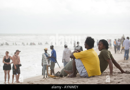 Junge Männer sitzen auf dem Sand am Strand Points in Accra Ghana Stockfoto