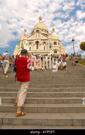 Touristen posieren für Fotos auf den Stufen des Sacre Coeur Montmartre - Paris Frankreich Stockfoto