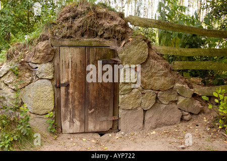 Rustikaler Steinkeller mit Holztür im Mazowsze Open Air Museum in Sierpc, Polen, mit traditioneller ländlicher Architektur. Stockfoto