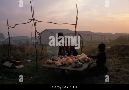 Südafrika Eastern Cape Port Elizabeth Township Frauen und Kinder verkaufen Obst aus provisorischen stall in in der Abenddämmerung Stockfoto