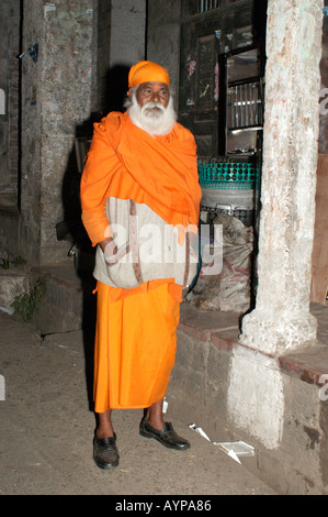 Sadhu Heiliger Indianer mit langem weißen Bart, orangefarbenem Gewand und Turban, stehend draußen in Indien. Stockfoto