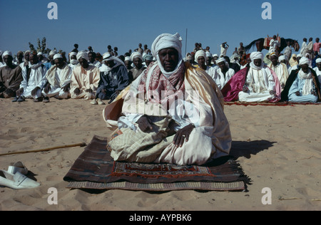 CHAD Zentralafrika Religion Islam Muslim Chef sitzen am Boden im Gebet während Festivals Menschenmenge umgeben Stockfoto